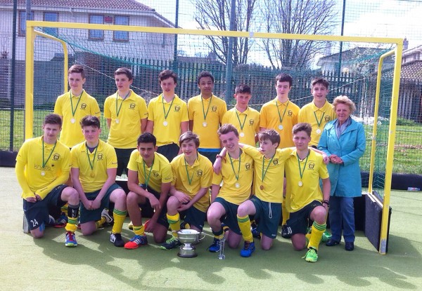 Pictured Above: Railway Squad, pictured above: Conor Fogarty (captain), Adam Kealy, Sam Staunton, Will Cosgrave, Jake Pillow, Shomik Chakraborty (GK), Tadgh McDonough Cunningham, Mateusz Nowakowski, Frankie Witte, Kituru Ndee, Conor Gallagher, Sasha Kuechenmeister, pictured alongside Valerie O’Meara. Image courtesy Railway Hockey.